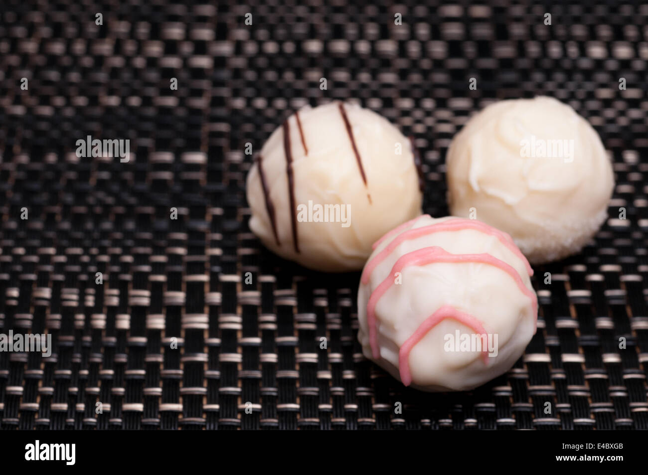 Three white chocolates on dark cloth Stock Photo