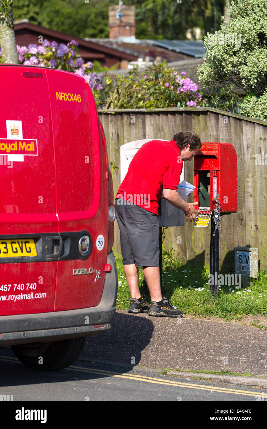 Postman emptying letter post box after collection of mail. Norfolk Broads England UK Stock Photo
