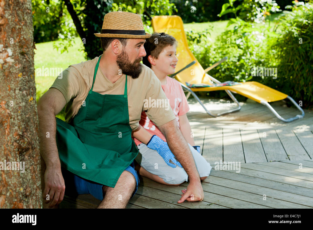 Father and son taking a break in the garden, Munich, Bavaria, Germany Stock Photo