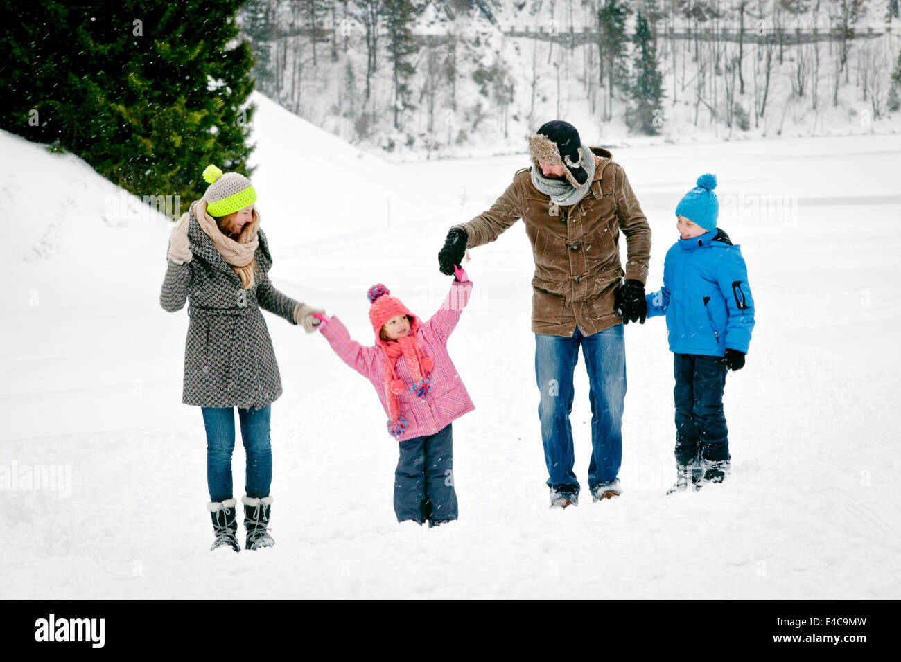 Family with two children in snow-covered landscape having fun, Bavaria, Germany Stock Photo