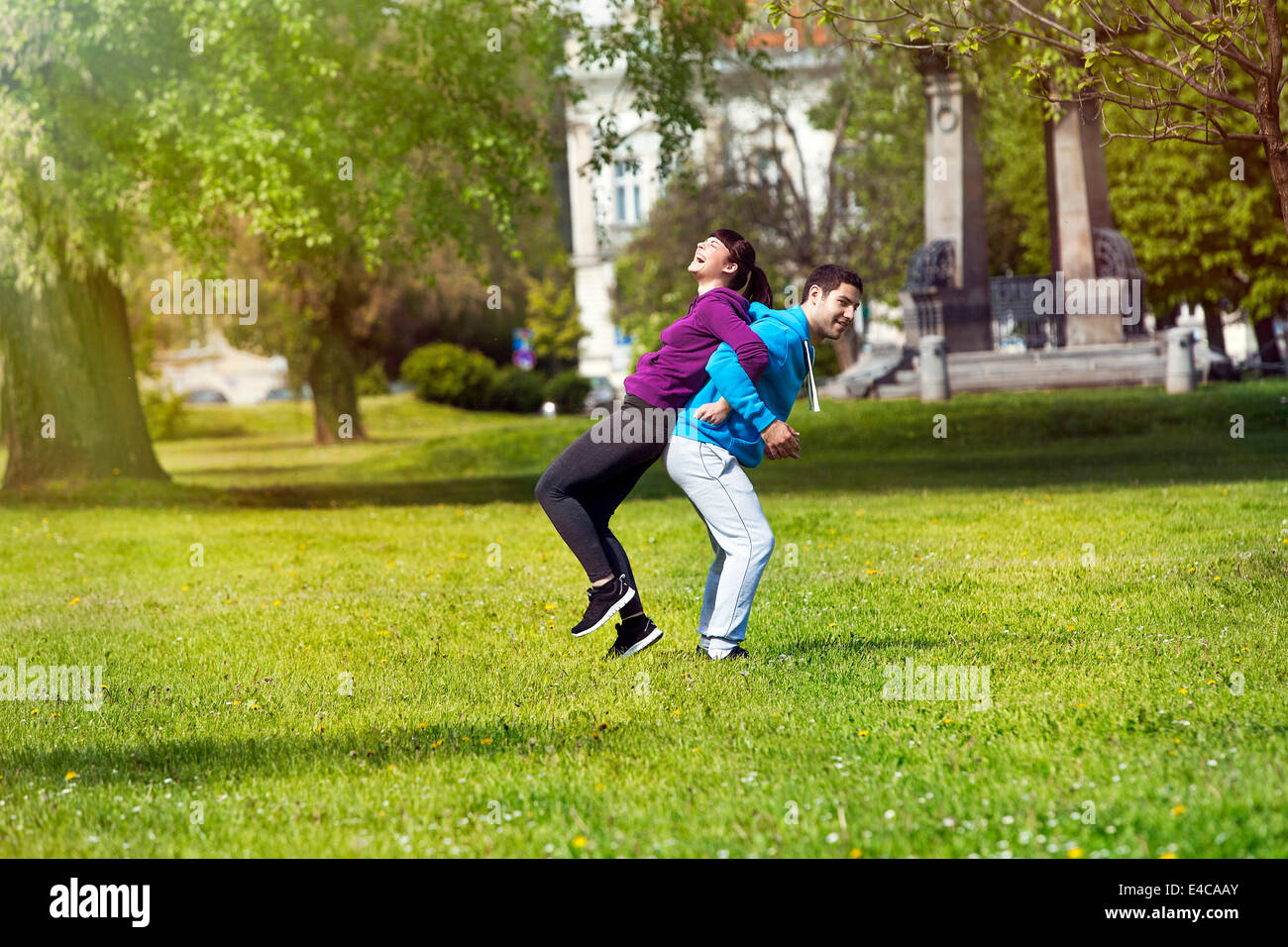 Man holding girlfriend on back in park, Osijek, Croatia Stock Photo
