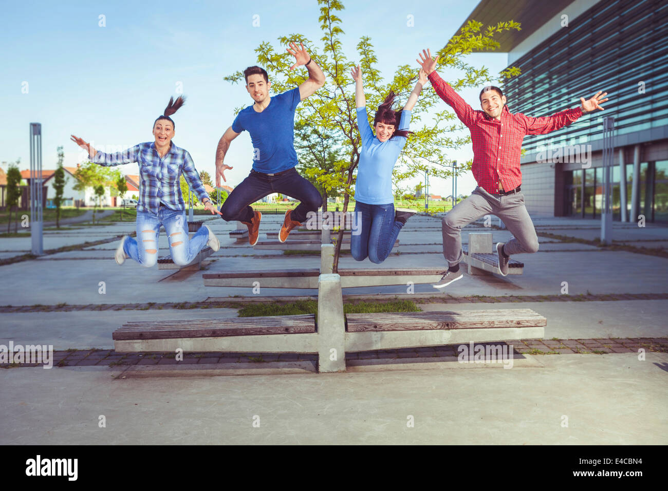 Friends jumping arms outstretched, Osijek, Croatia Stock Photo