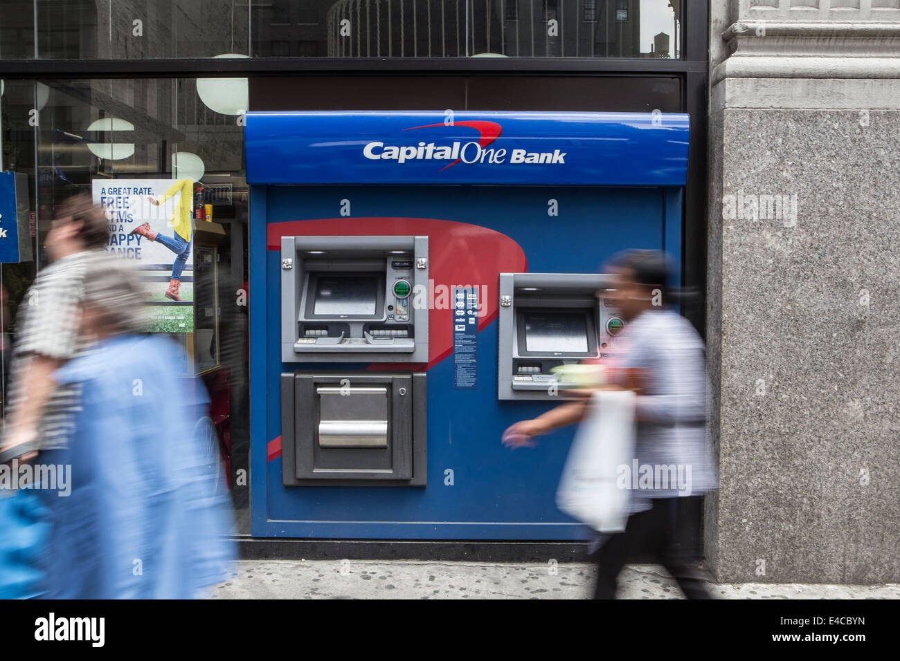 Pedestrians walk by a Capital One Bank ATM in the New York City borough of Manhattan, NY Stock Photo