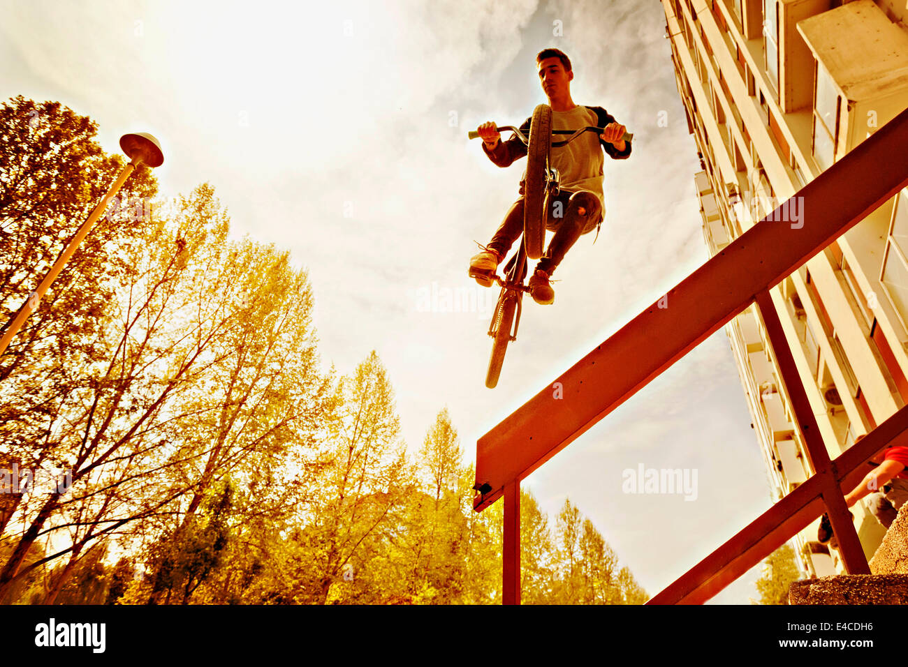 BMX biker performing a stunt over a railing Stock Photo