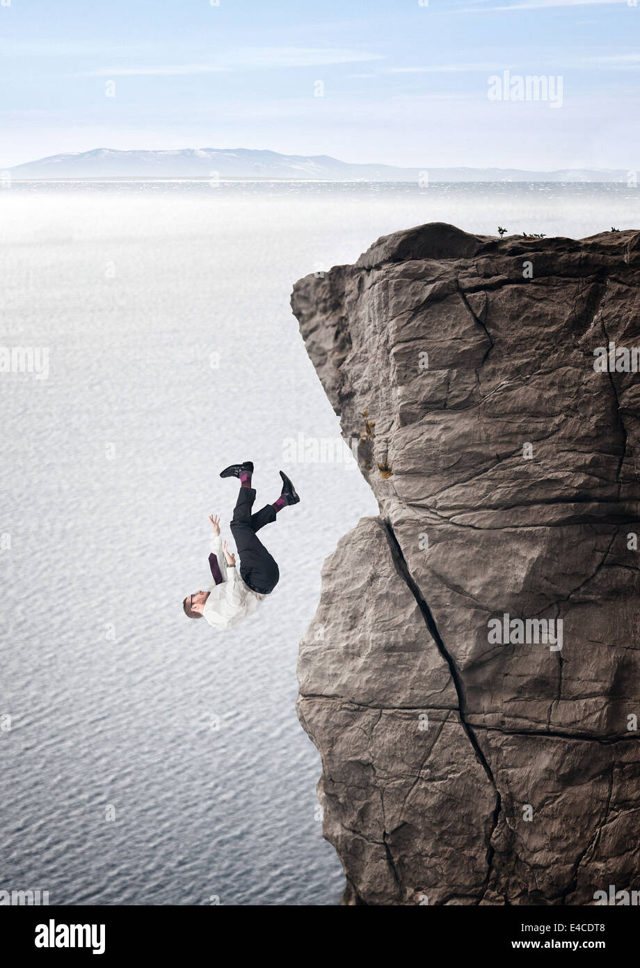 businessman fall from cliff sea background Stock Photo