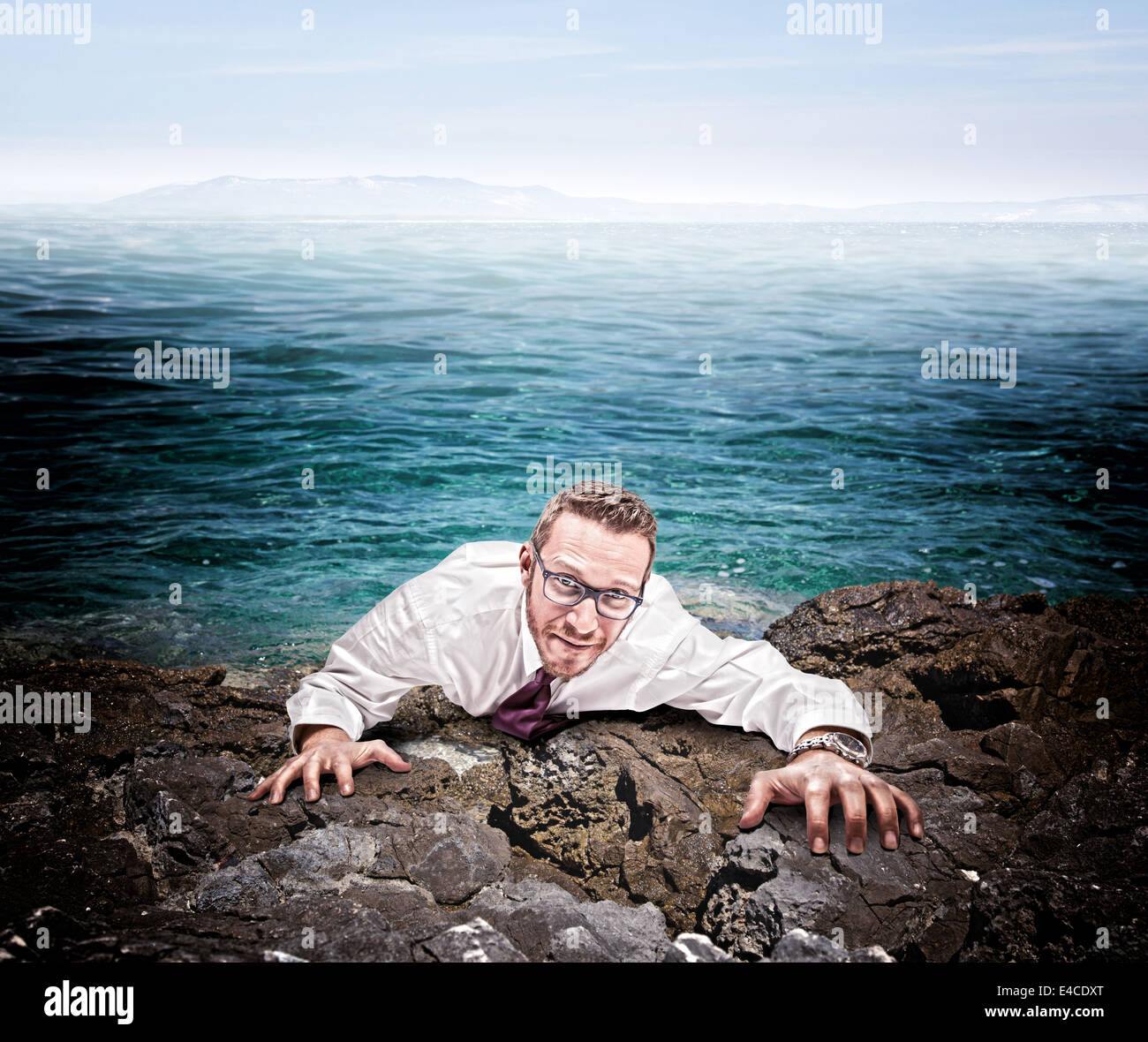 castaway businessman climb the cliff Stock Photo