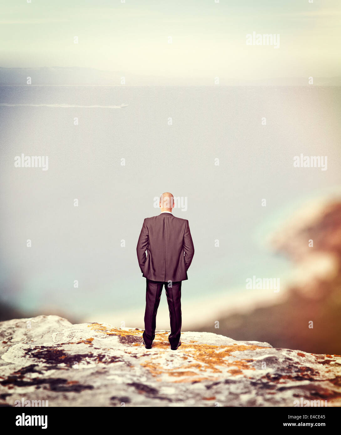 standing businessman on cliff looking the sea Stock Photo