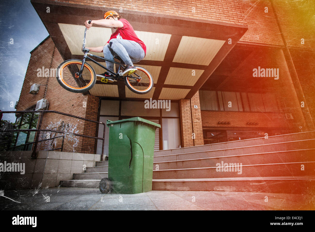 BMX biker jumping over a garbage can Stock Photo