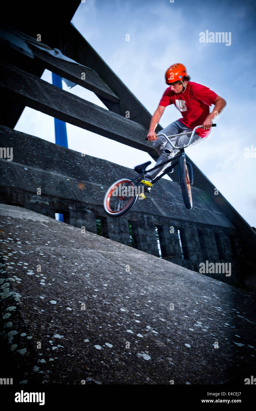 BMX biker performs a stunt on a bridge Stock Photo