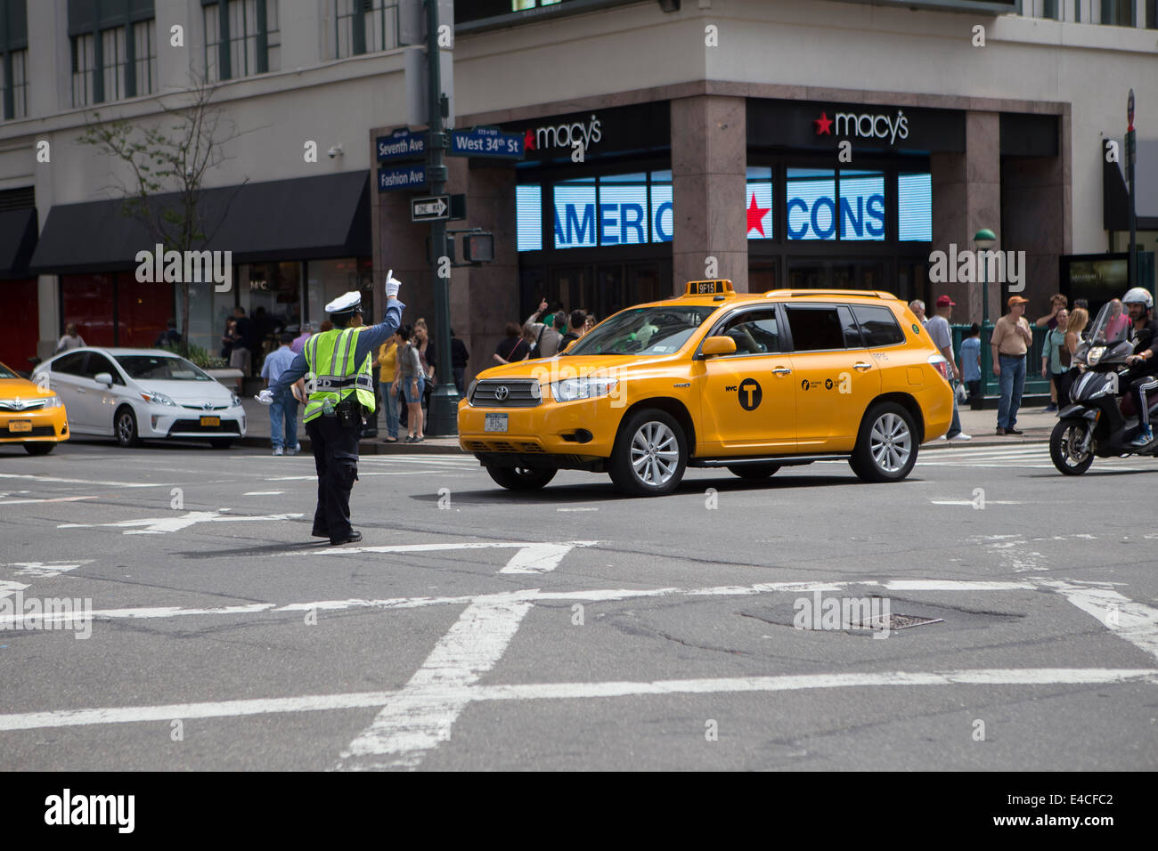 A police woman directs traffic at a busy intersection in the New York City borough of Manhattan, NY Stock Photo