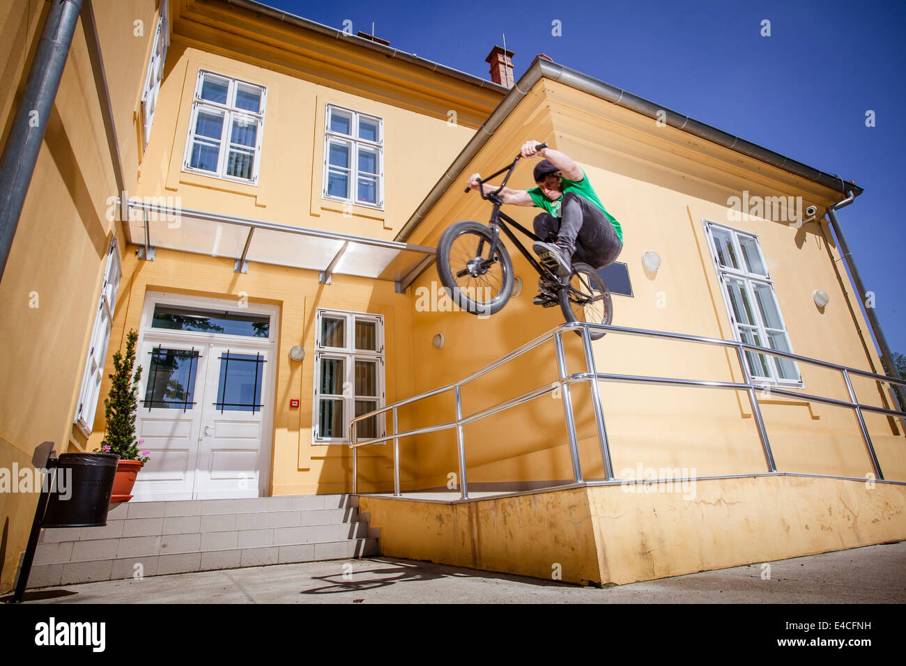 BMX biker jumping over a railing Stock Photo
