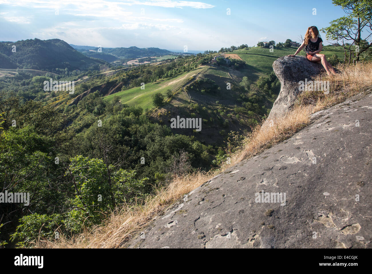 girl sitting on rock enjoying the view of the countryside Stock Photo