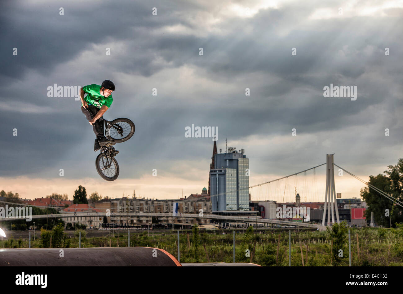 BMX biker performing a stunt against city skyline, Osijek, Croatia Stock Photo