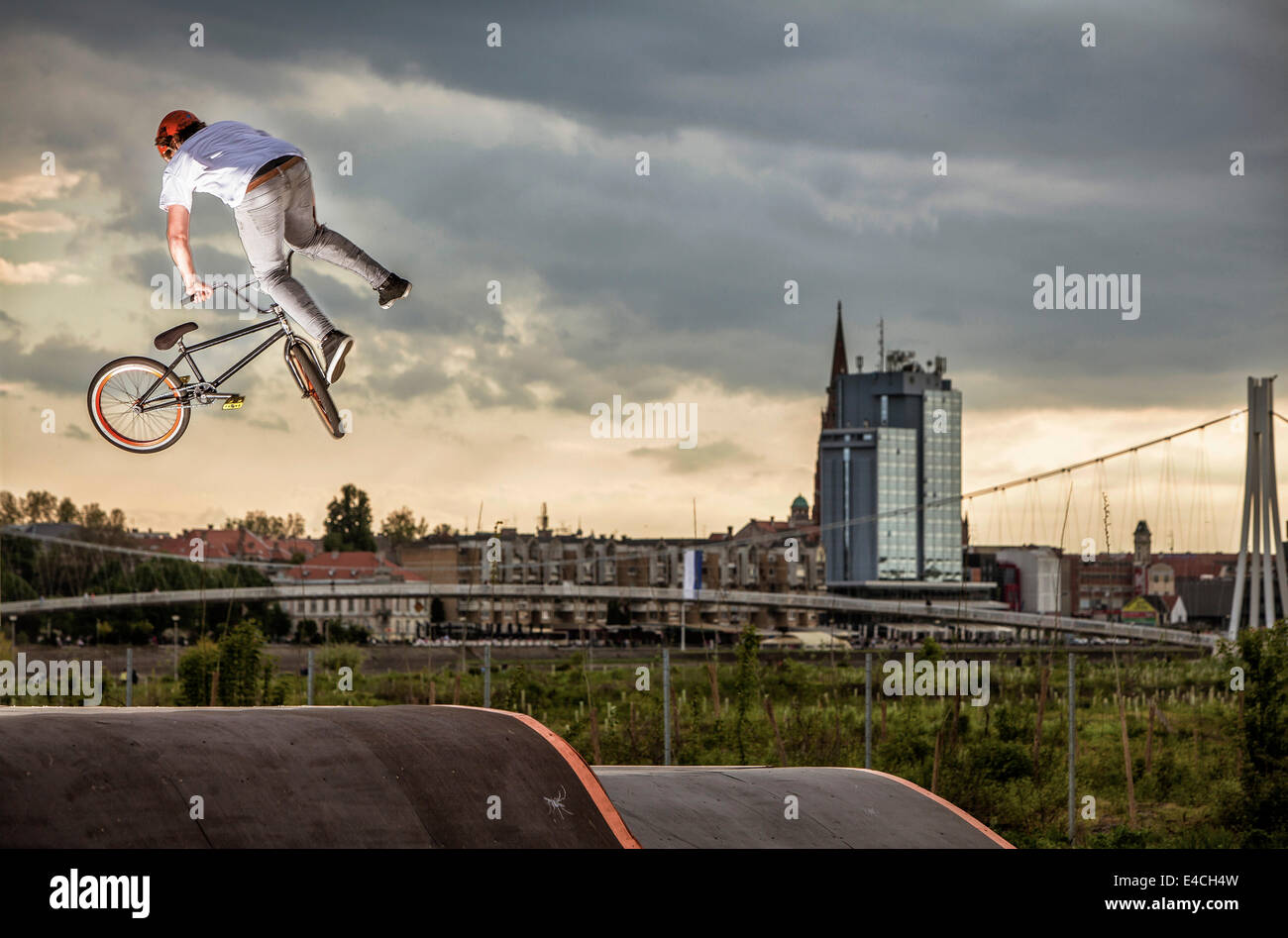 BMX biker performing a stunt against city skyline, Osijek, Croatia Stock Photo