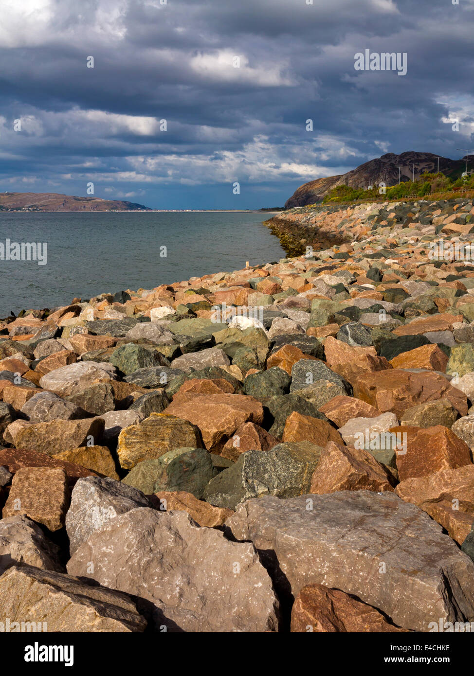 Sea defences on the North Wales coastline at Penmaenmawr in Conwy with large rocks and boulders used to prevent coastal erosion Stock Photo