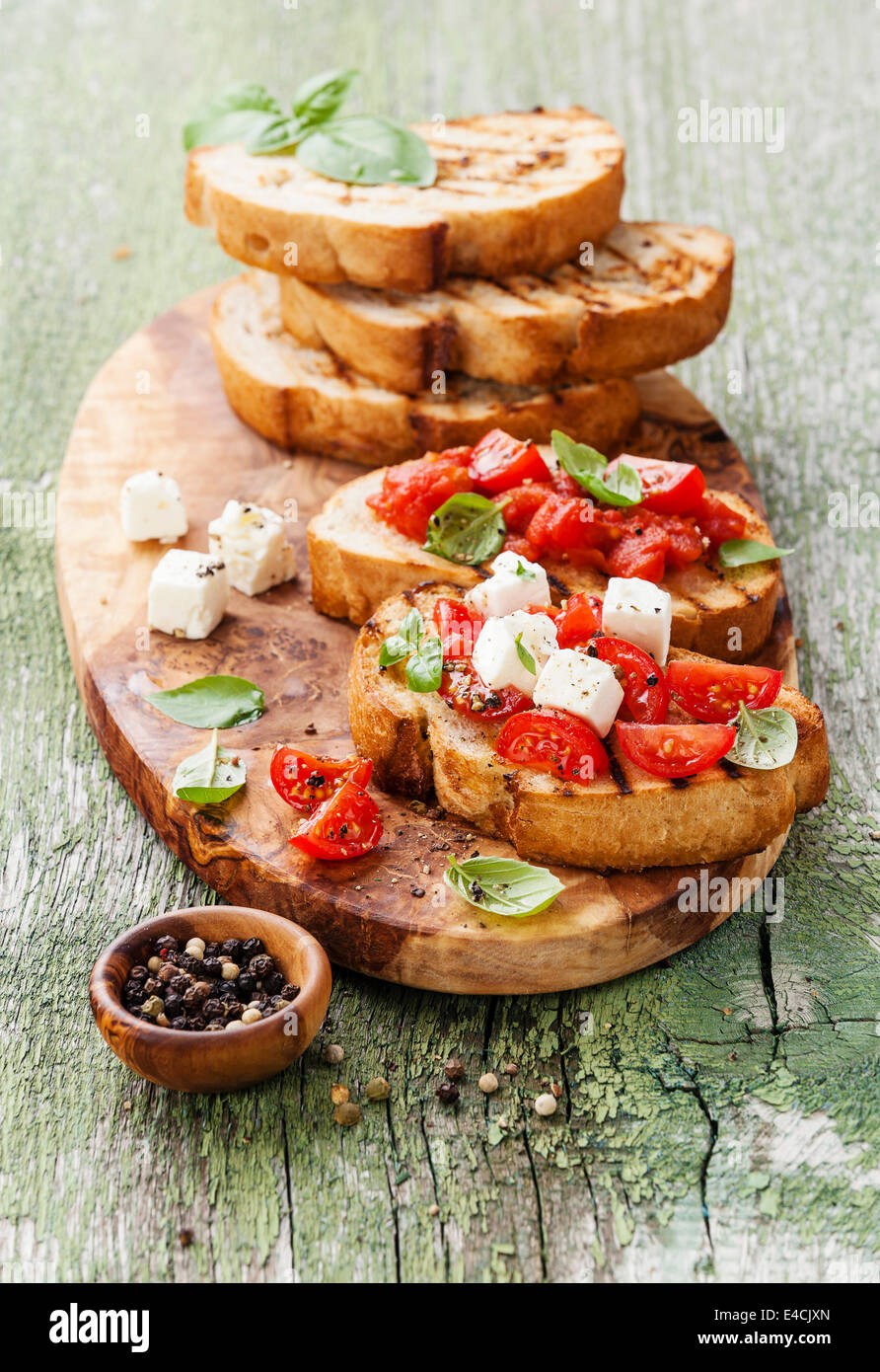 Italian bruschetta with chopped tomatoes, basil and cheese on grilled crusty bread Stock Photo