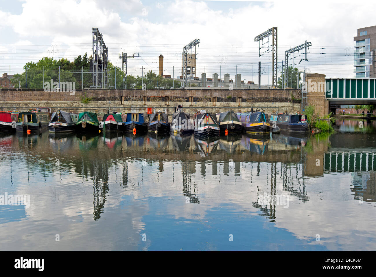 canal boats moored alongside the train line in King's Cross, London. Stock Photo