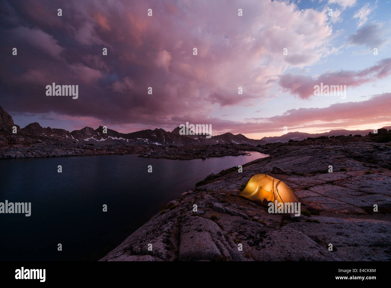 Big Agnes Fly creek tent pitched in the Dusy Basin of California's High Sierra Mountain range near a lake at sunset. Stock Photo