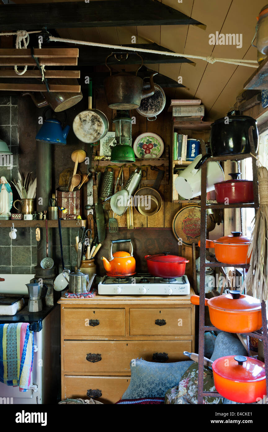 https://c8.alamy.com/comp/E4CKE1/le-creuset-pots-on-an-iron-rack-in-cluttered-country-kitchen-with-E4CKE1.jpg