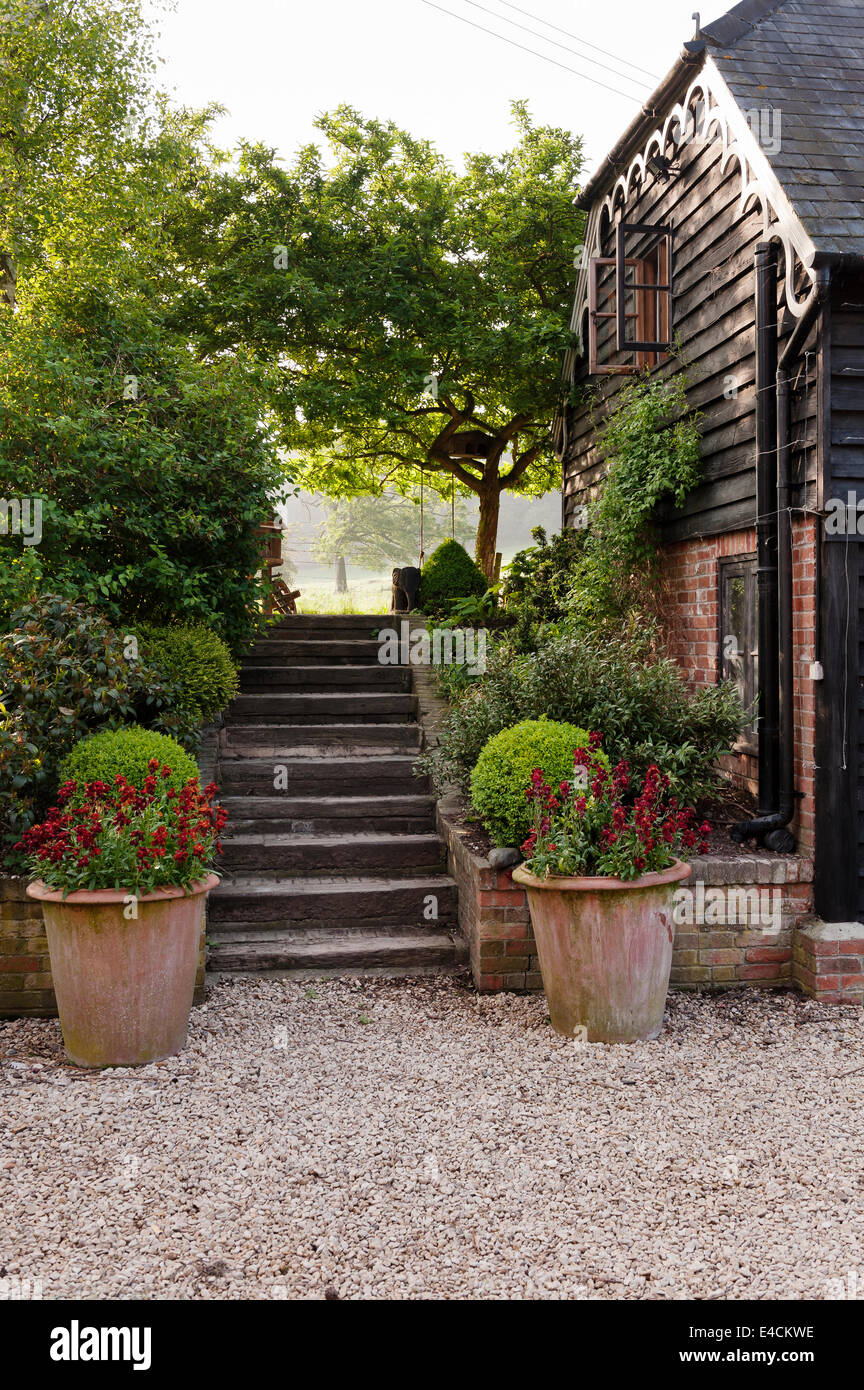 Exterior facade of old cottage with steps leading to garden Stock Photo