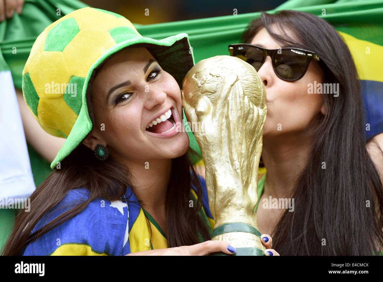 Belo Horizonte, Brazil. 08th July, 2014. Two female supporters of Brazil hold a mock-up world cup trophy prior to the FIFA World Cup 2014 semi-final soccer match between Brazil and Germany at Estadio Mineirao in Belo Horizonte, Brazil, 08 July 2014. Photo: Marcus Brandt/dpa/Alamy Live News Stock Photo