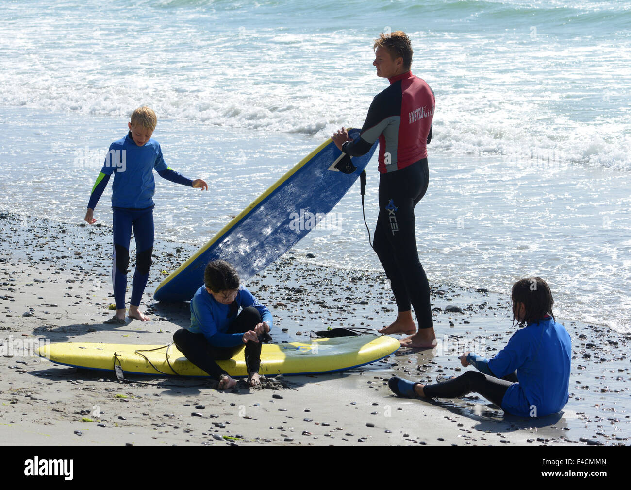 Children being taught how to surf with surfing instructor Stock Photo