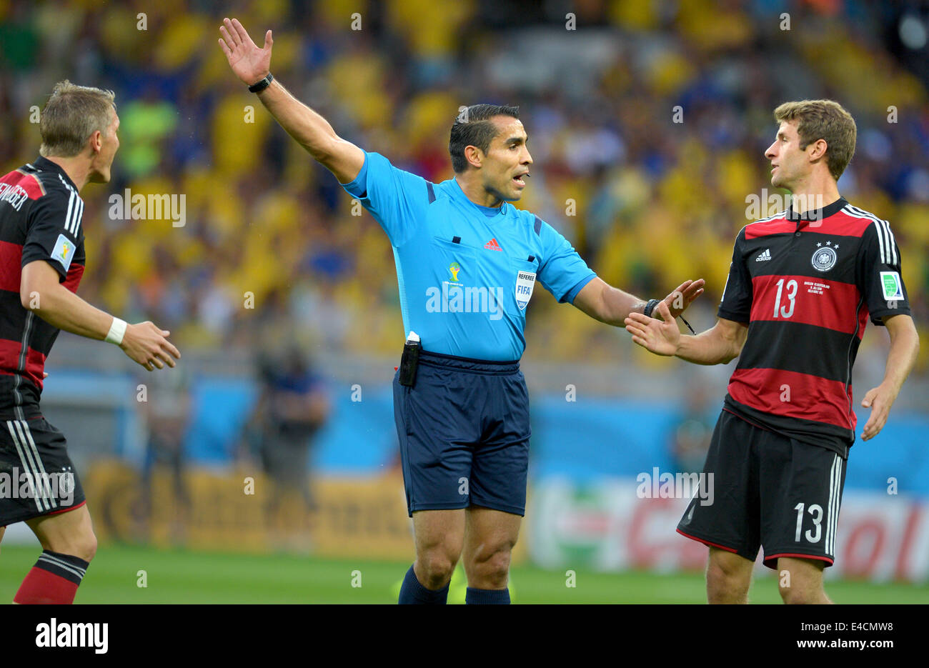 Belo Horizonte, Brazil. 08th July, 2014. Referee Marco Rodriguez (C) of Mexico gestures next to Thomas Mueller (R) of Germany during the FIFA World Cup 2014 semi-final soccer match between Brazil and Germany at Estadio Mineirao in Belo Horizonte, Brazil, 08 July 2014. Photo: Thomas Eisenhuth/dpa/Alamy Live News Stock Photo