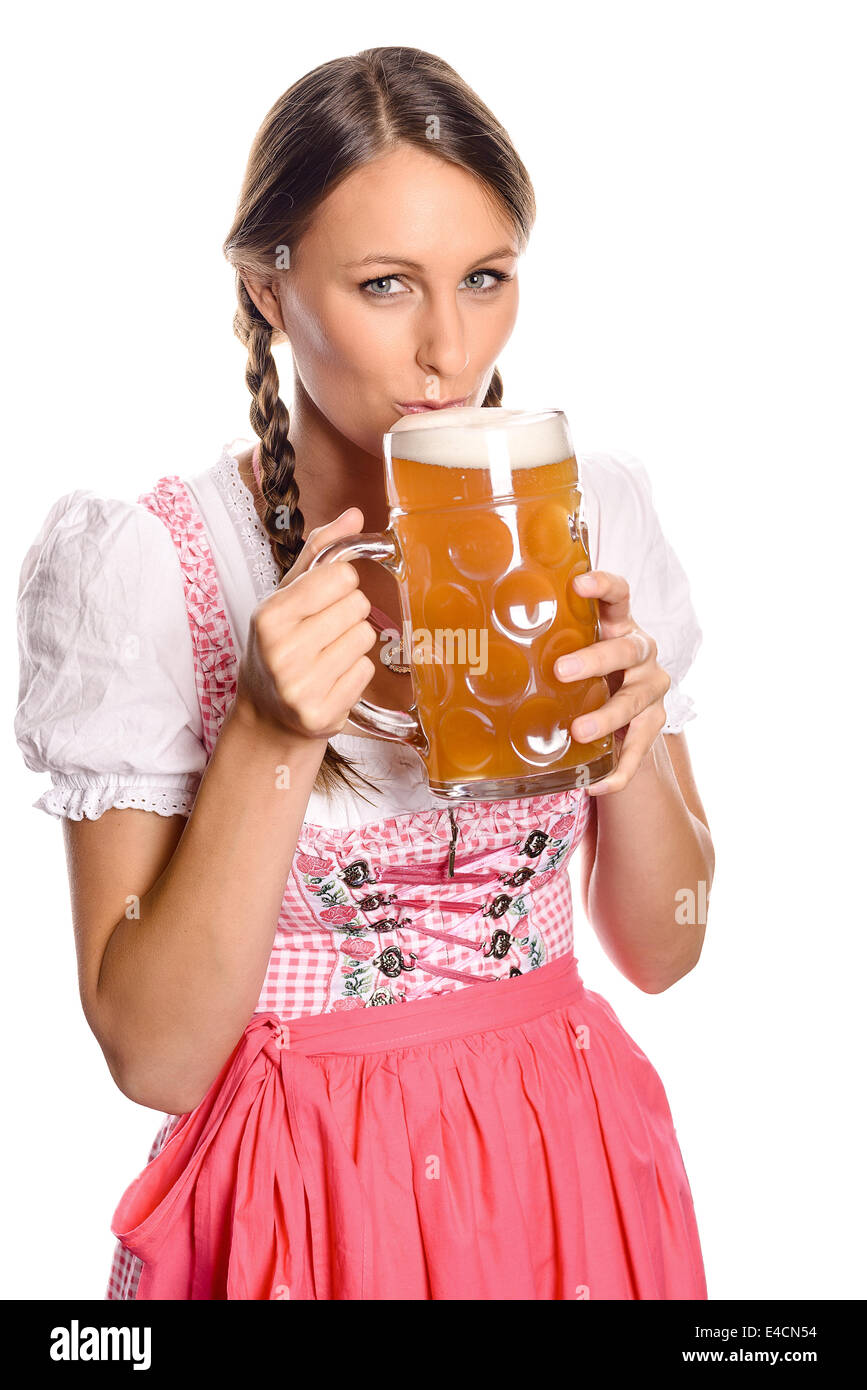 Attractive young woman with her hair in plaits wearing a dirndl drinking beer from a very large glass tankard with a look of ant Stock Photo