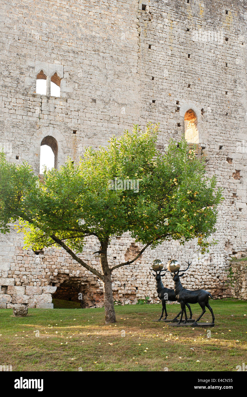 A pair of bronze stags with silver balls between their antlers in garden under an apple tree set against the backdrop of an 11th Stock Photo