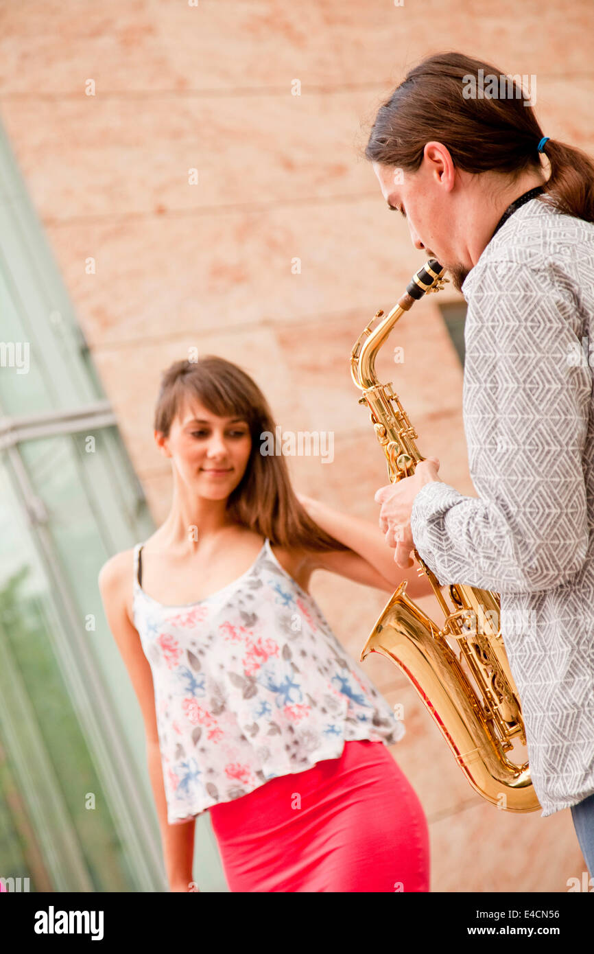 Man playing the saxophone to woman, Osijek, Croatia Stock Photo