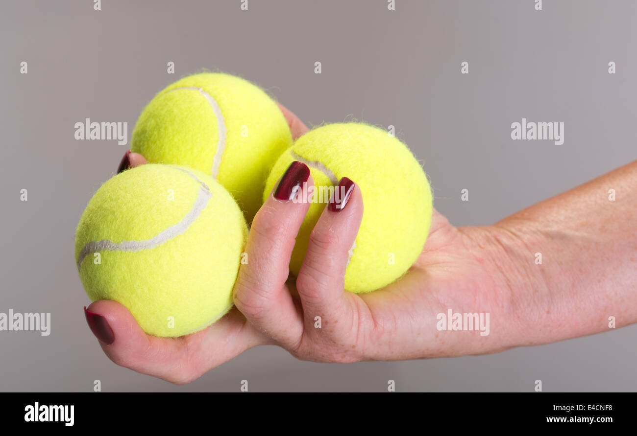 Sporting equipment three tennis balls in a female players hand Stock Photo Alamy