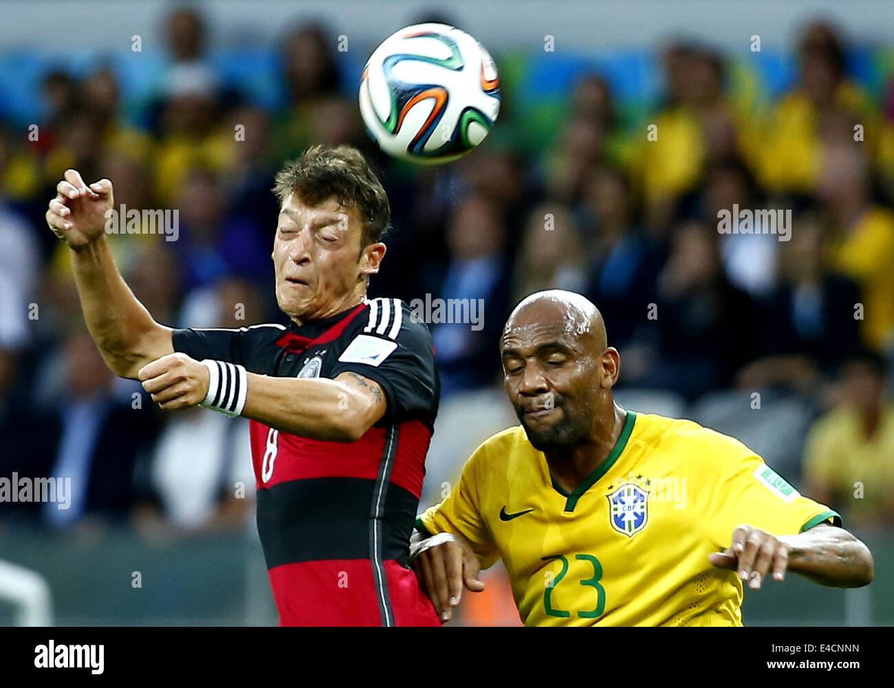 Belo Horizonte, Brazil. 8th July, 2014. Brazil's Maicon competes for a header with Germany's Mesut Ozil during a semifinal match between Brazil and Germany of 2014 FIFA World Cup at the Estadio Mineirao Stadium in Belo Horizonte, Brazil, on July 8, 2014. Credit:  Chen Jianli/Xinhua/Alamy Live News Stock Photo