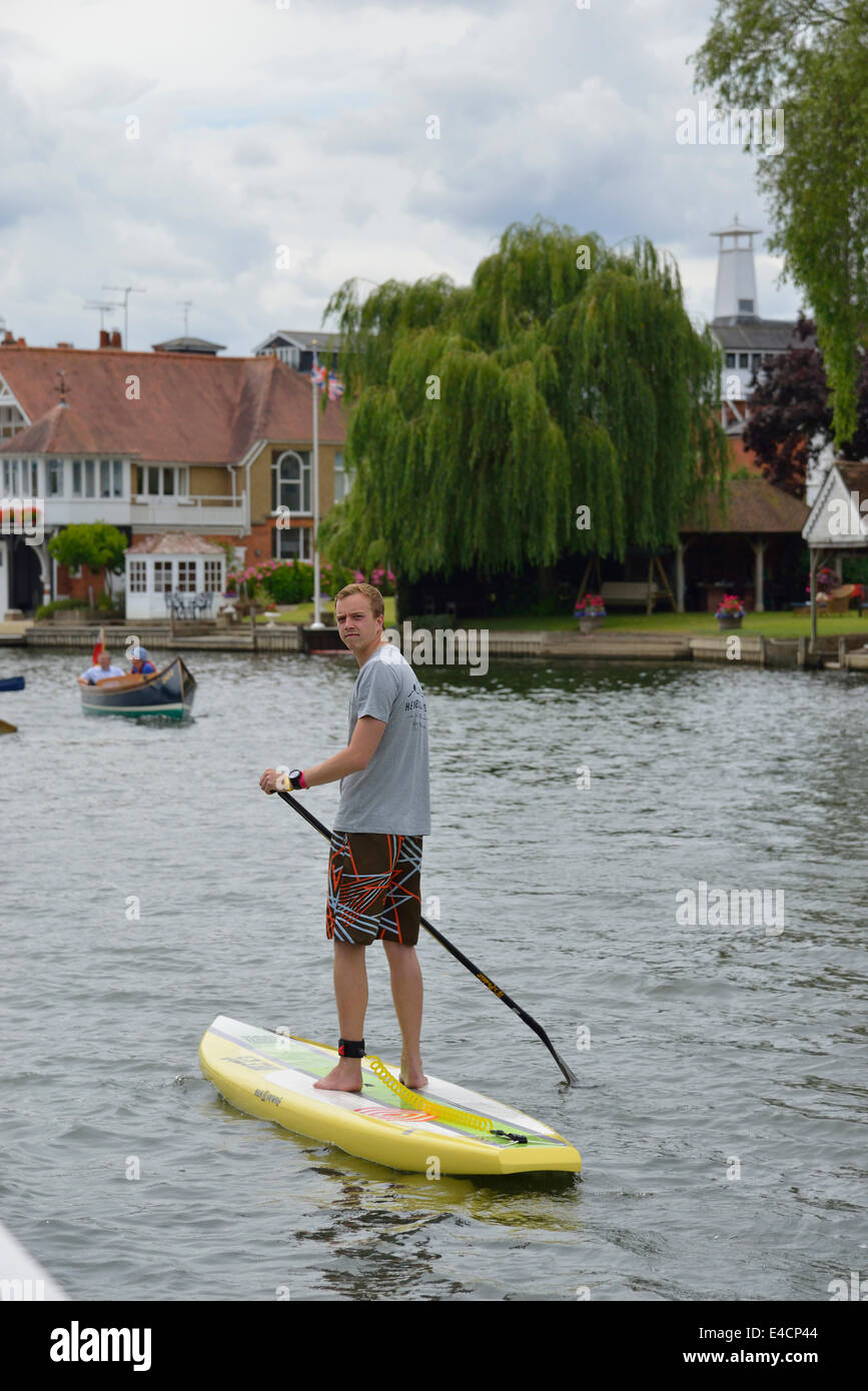 Male paddle boarder on the River Thames at the Henley Royal Regatta 2014, Henley on Thames, Oxfordshire, England, UK Stock Photo