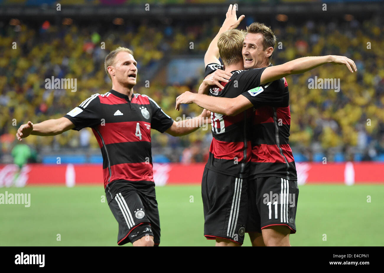 Belo Horizonte, Brazil. 08th July, 2014. Toni Kroos (C) of Germany celebrates with his teammmates Miroslav Klose (R) and Benedikt Hoewedes (L) after scoring 0-3 goal during the FIFA World Cup 2014 semi-final soccer match between Brazil and Germany at Estadio Mineirao in Belo Horizonte, Brazil, 08 July 2014. Photo: Marcus Brandt/dpa/Alamy Live News Stock Photo