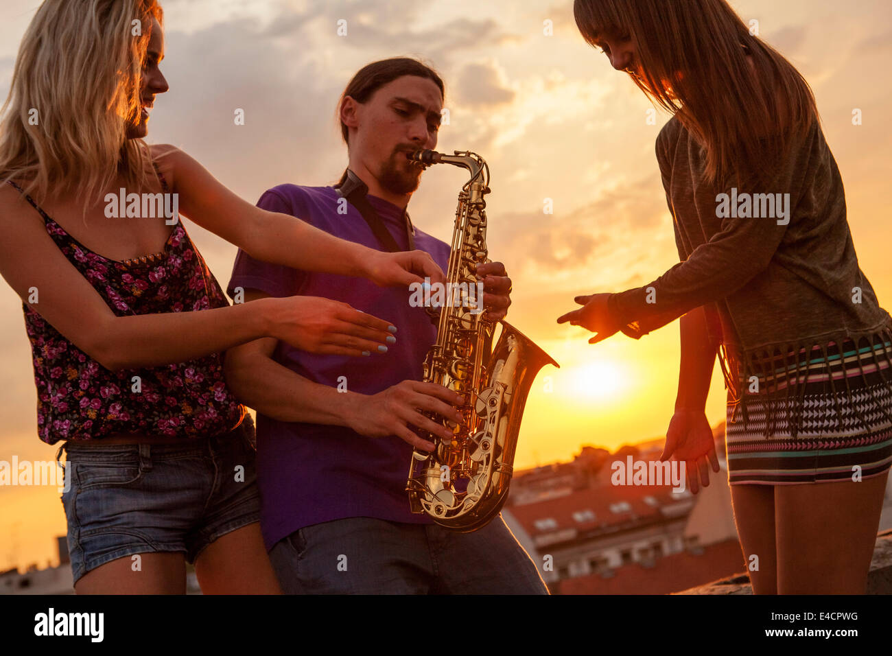Young man playing the saxophone at sunset, Osijek, Croatia Stock Photo