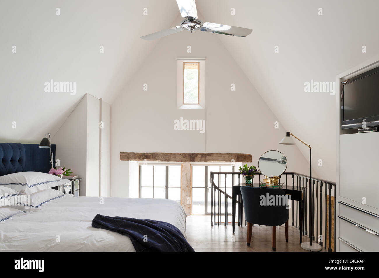 Dark Blue Buttoned Headboard On Bed In White Bedroom With