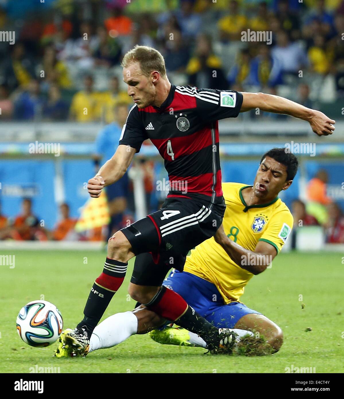 Belo Horizonte, Brazil. 8th July, 2014. Brazil's Paulinho vies with Germany's Benedikt Howedes during a semifinal match between Brazil and Germany of 2014 FIFA World Cup at the Estadio Mineirao Stadium in Belo Horizonte, Brazil, on July 8, 2014. Credit:  Chen Jianli/Xinhua/Alamy Live News Stock Photo