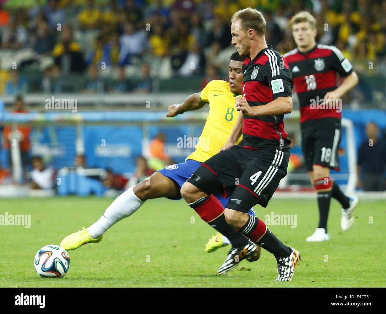 Belo Horizonte, Brazil. 8th July, 2014. Brazil's Paulinho vies with Germany's Benedikt Howedes during a semifinal match between Brazil and Germany of 2014 FIFA World Cup at the Estadio Mineirao Stadium in Belo Horizonte, Brazil, on July 8, 2014. Credit:  Chen Jianli/Xinhua/Alamy Live News Stock Photo