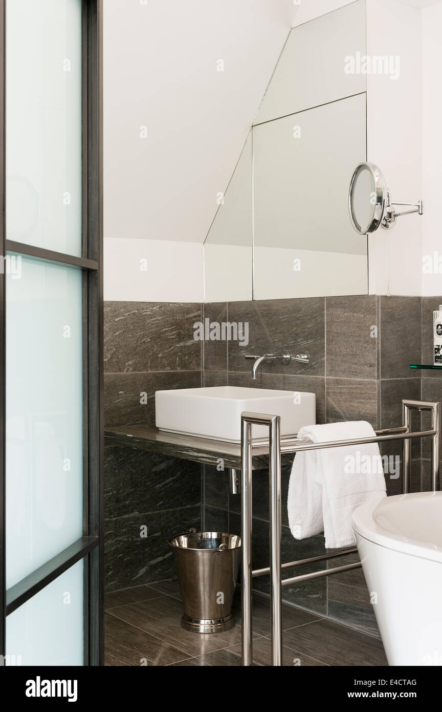 Modern bathroom with granite tiling and steel towel rail Stock Photo