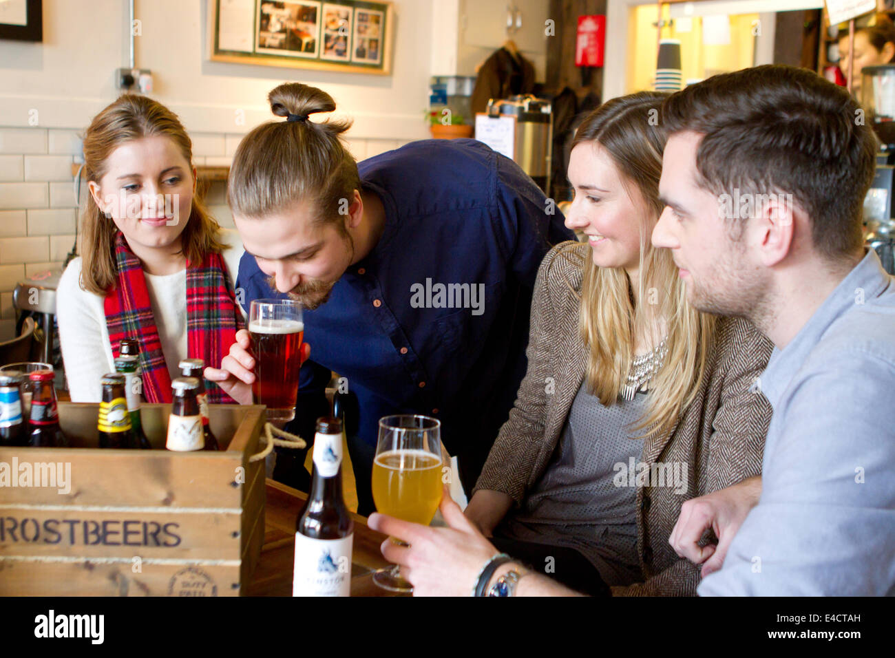 Young men smelling and tasting beer in pub, Dorset, Bournemouth