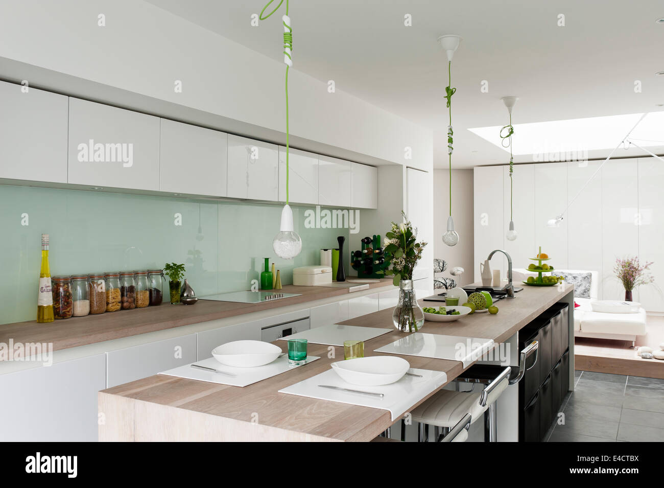 Modern kitchen from Beeck kuechen. The green corded pendant lights are by Nud and the barstools by Dwell Stock Photo