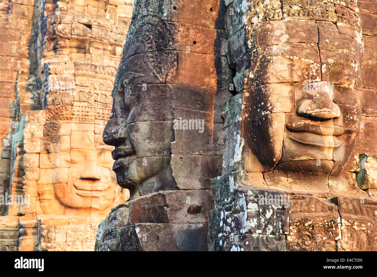 Carved faces in the sunset at the Bayon Temple, Angkor temple complex, Angkor Wat, Siem Reap, Cambodia. Stock Photo