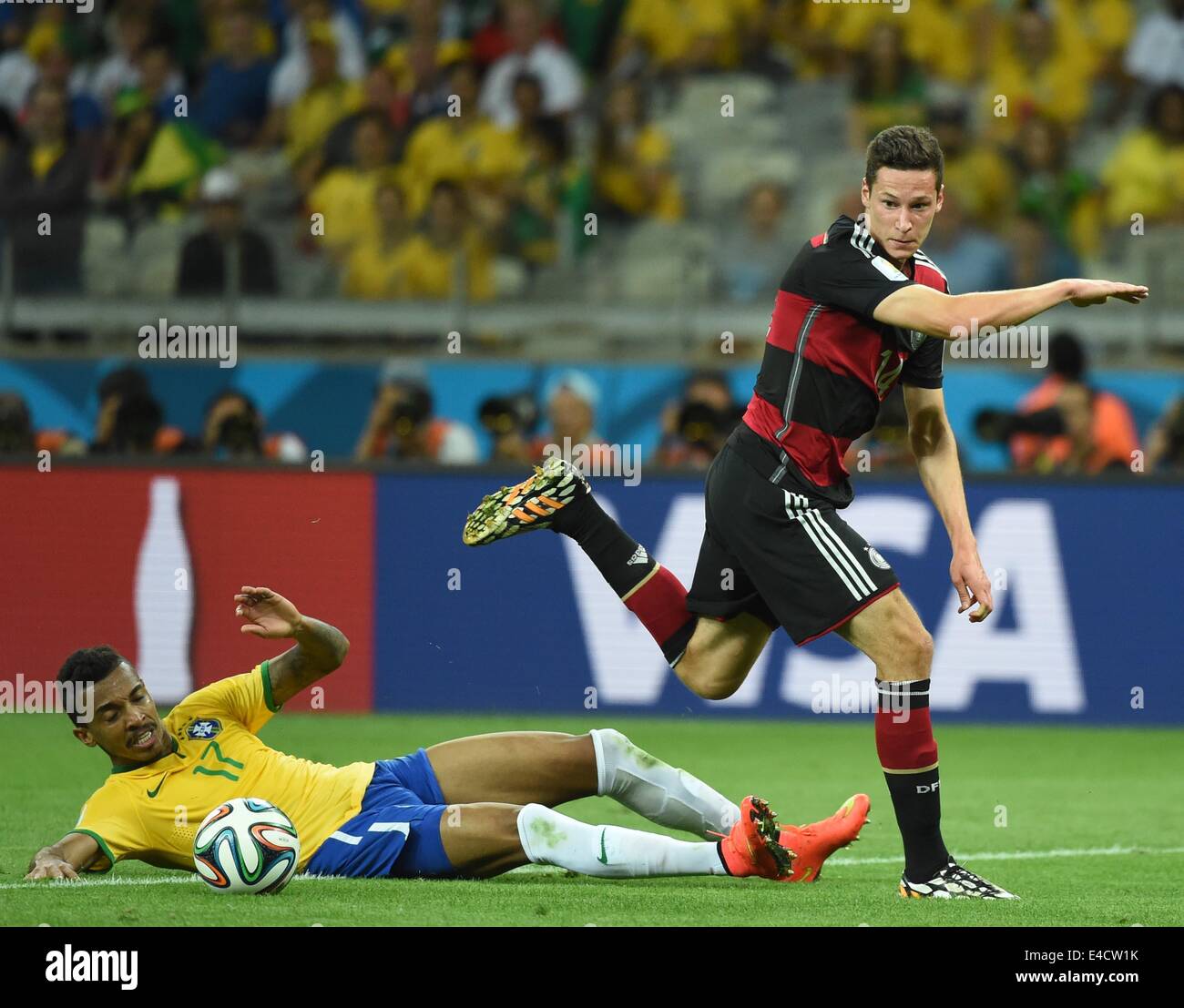 Belo Horizonte, Brazil. 8th July, 2014. Germany's Julian Draxler (R) vies with Brazil's Luiz Gustavo during a semifinal match between Brazil and Germany of 2014 FIFA World Cup at the Estadio Mineirao Stadium in Belo Horizonte, Brazil, on July 8, 2014. Germany won 7-1 over Brazil and qualified for the final on Tuesday. Credit:  Liu Dawei/Xinhua/Alamy Live News Stock Photo