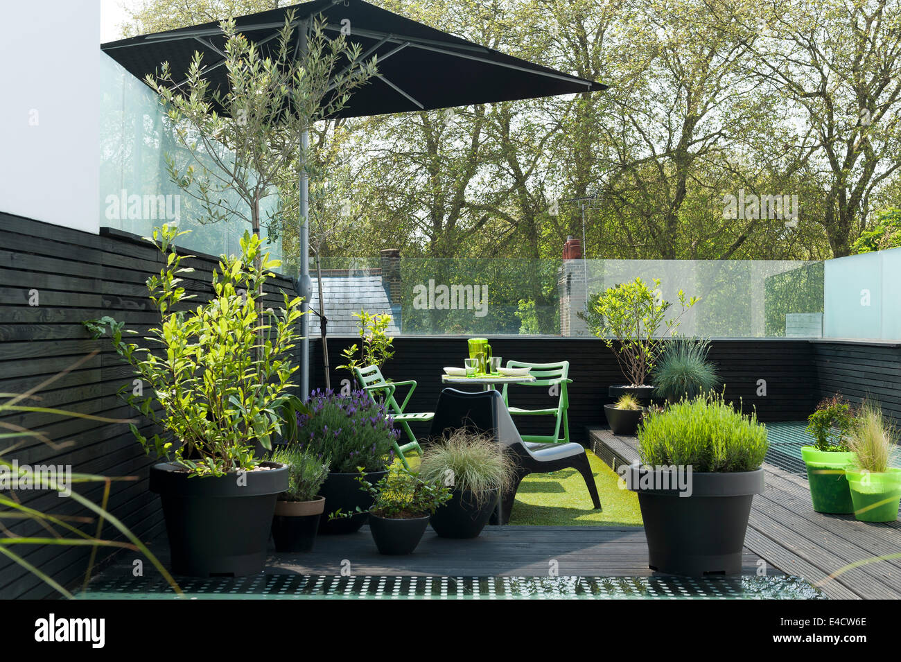Outdoor furniture and potted plants on modern roof terrace Stock Photo