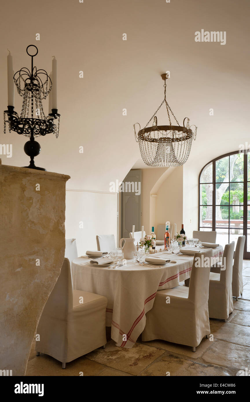 Vaulted dining room with 19th century crystal light and candelabra, french linen table cloth and chairs from the Padova designs Stock Photo