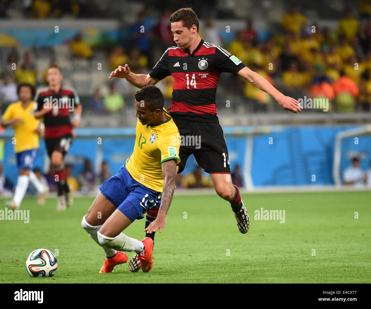 Belo Horizonte, Brazil. 8th July, 2014. Brazil's Luiz Gustavo (L) vies with Germany's Julian Draxler during a semifinal match between Brazil and Germany of 2014 FIFA World Cup at the Estadio Mineirao Stadium in Belo Horizonte, Brazil, on July 8, 2014. Germany won 7-1 over Brazil and qualified for the final on Tuesday. Credit:  Li Ga/Xinhua/Alamy Live News Stock Photo