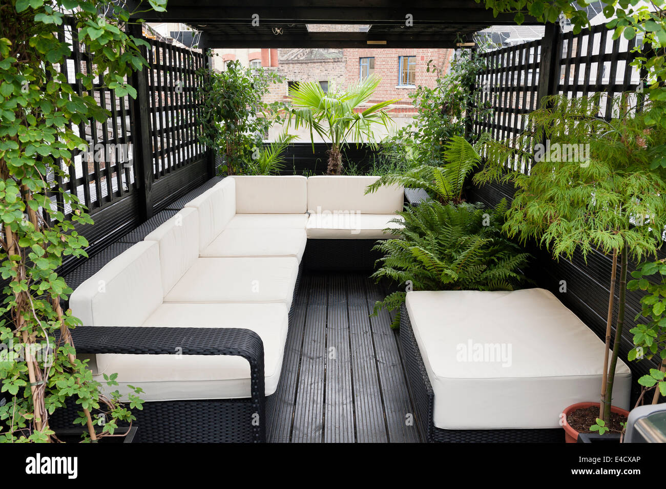 Rattan furniture on roof terrace with trellis Stock Photo