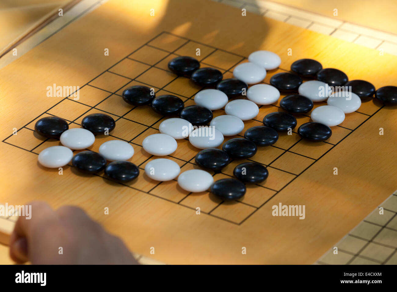 People playing game of Go on beginner board Stock Photo