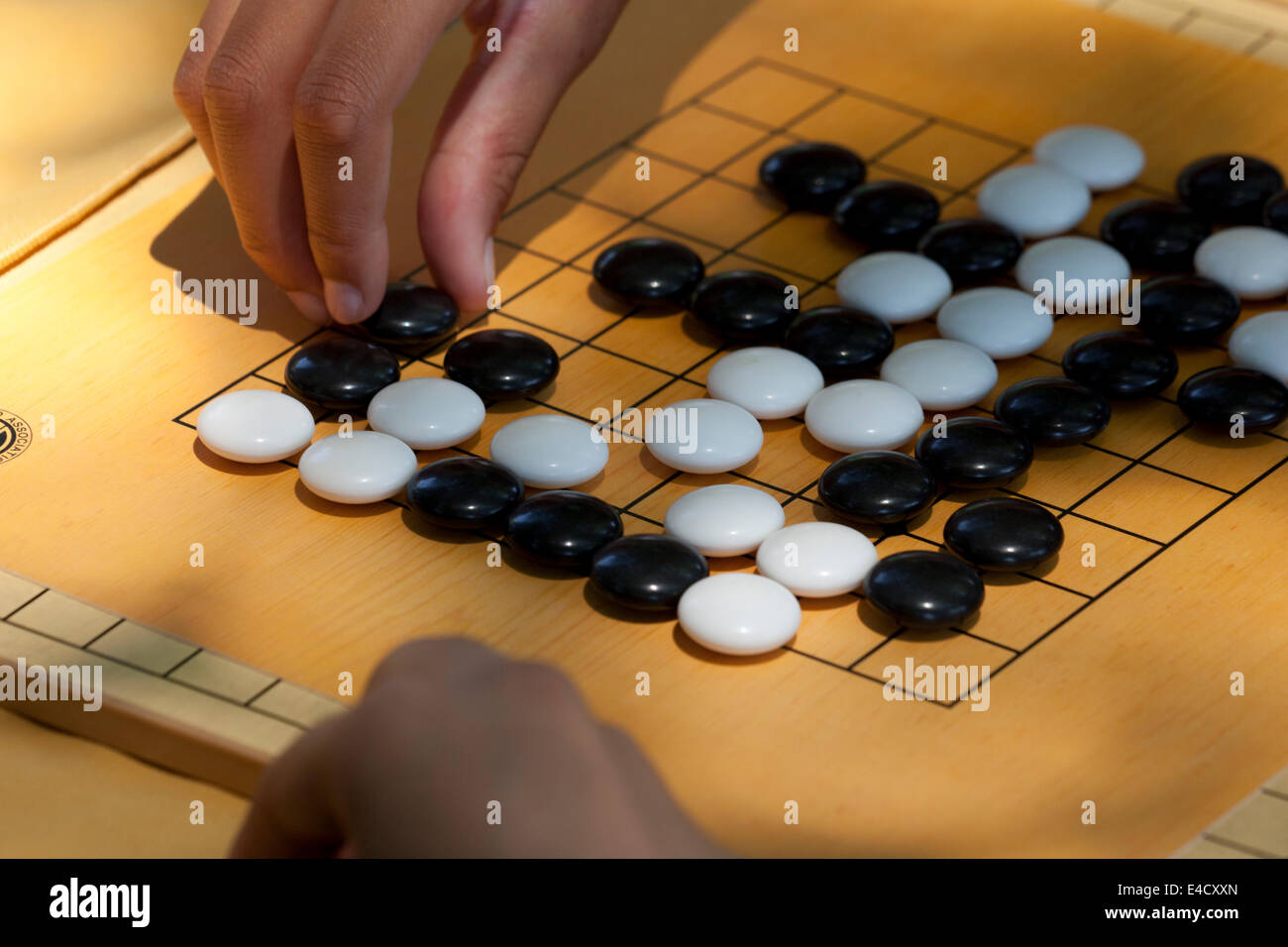 People playing game of Go on beginner board Stock Photo