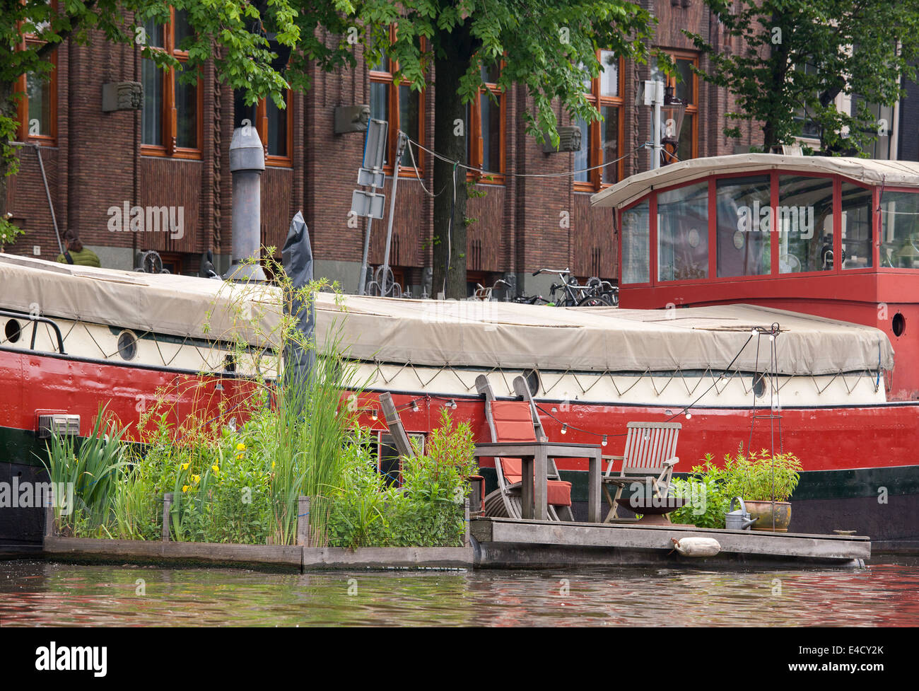 Amsterdam barge house boat with floating garden in the Kromme Waal Canal next to the Amrath Hotel Stock Photo